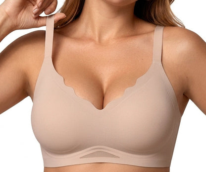 A close-up of a woman wearing a Nude wireless bra with scalloped edges and wide shoulder straps, shown against a plain white background.